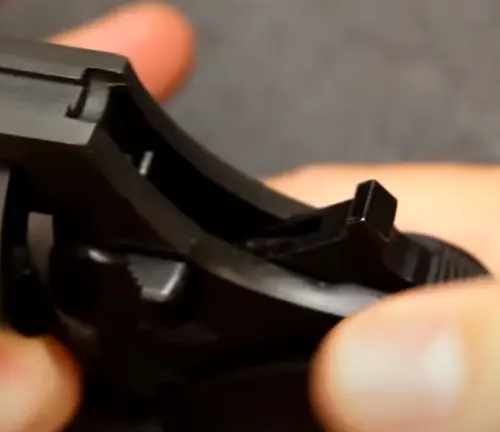 Close-up view of a hand holding the rear sight of a Smith & Wesson M&P Bodyguard 38 revolver.