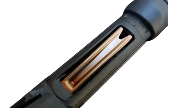 Detail of a shotgun's ejection port with a brass shell visible, highlighting the firearm's loading mechanism