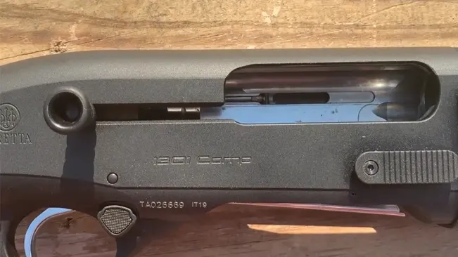 Close-up of a Beretta 1301 Comp semi-automatic shotgun, showing the model details 