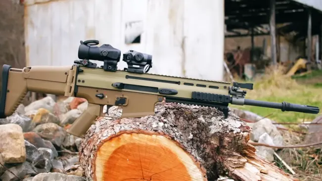 FN SCAR 17S rifle with optic sight mounted on log against rural backdrop