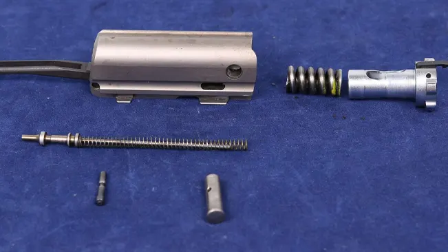 Disassembled parts of a Browning A5 Hunter shotgun on a blue background