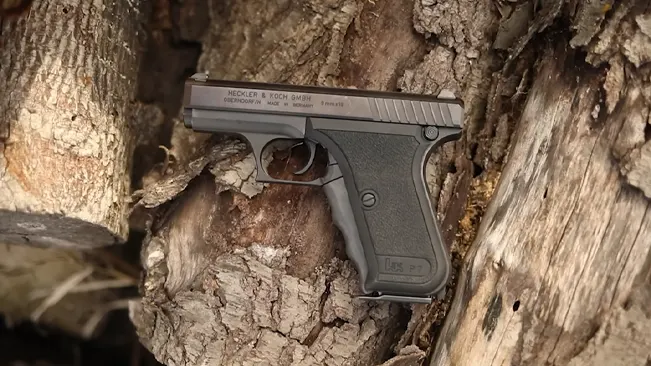 The HK P7 PSP pistol placed in a tree bark crevice.