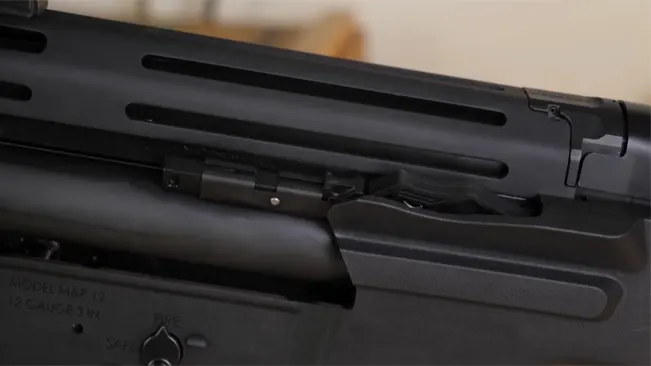 Detailed view of the S&W M&P 12 shotgun's upper receiver and vented barrel shroud, with a focus on the ejection port.