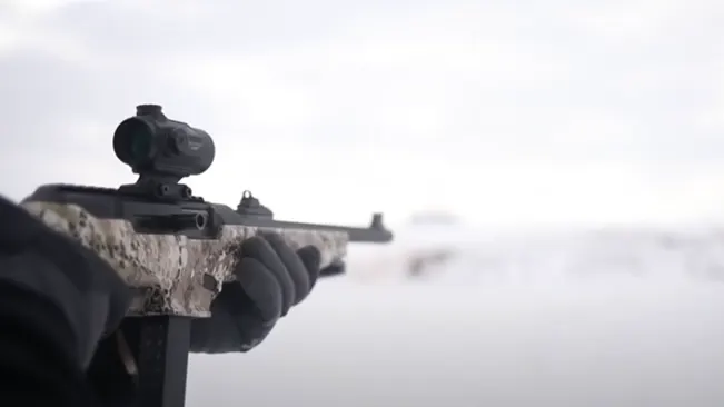 a hand of a person using the Ruger PC Carbine in a snow shooting range
