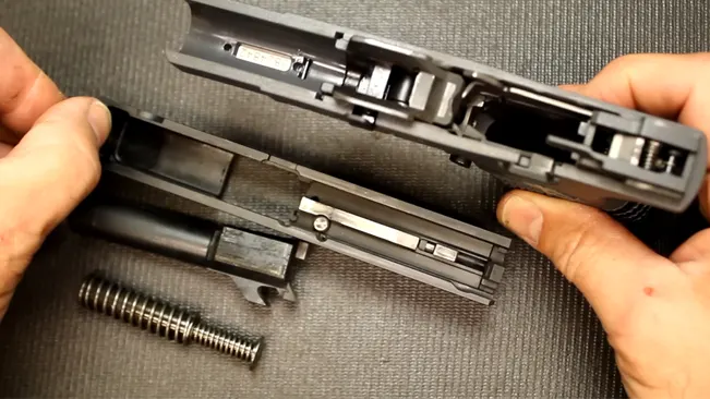 Disassembled Springfield XD-S handgun with slide, barrel, and recoil spring