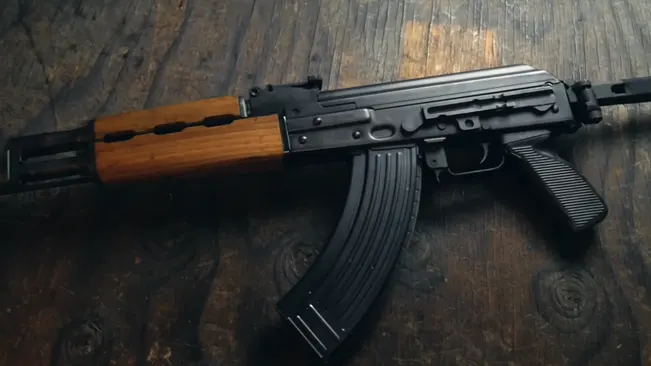 Zastava M70 ZPAP rifle with wooden furniture on textured wood floor.