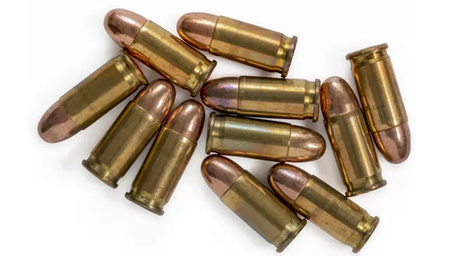 A group of copper-colored bullets with brass casings scattered randomly on a white background.