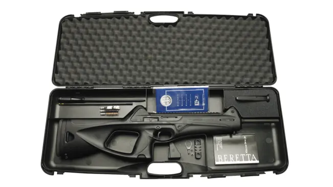 A Beretta-branded hard case open to reveal a black bolt-action rifle disassembled into components, with a cleaning kit and a user manual.