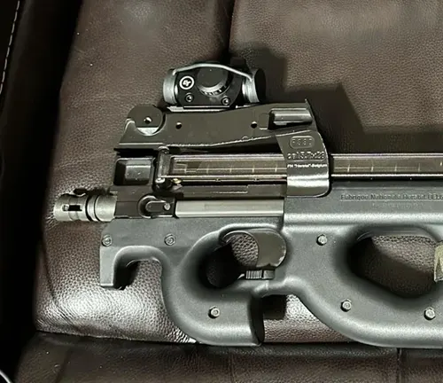 FN PS90 with red dot optic on a leather surface