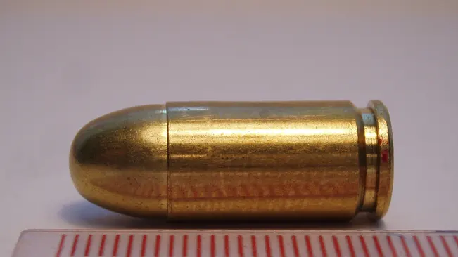 A .380 ACP caliber bullet, potentially for use with a Walther PK380 pistol, displayed against a ruled background for scale.