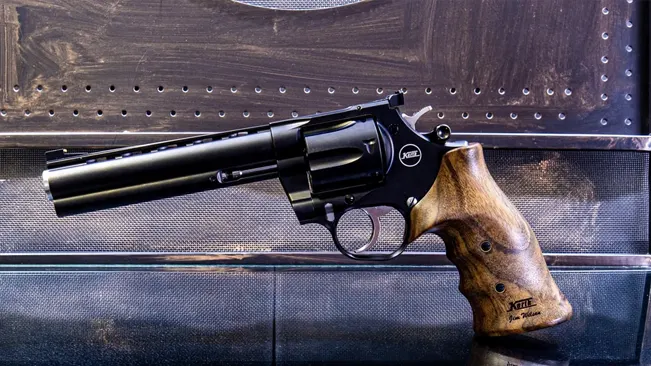 Korth Nighthawk Mongoose revolver with a wooden grip on a metal textured background.