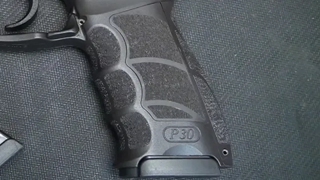Close-up of the grip and lower frame of an HK P30L handgun showing textured grip panels and P30 marking