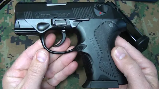 Hands holding a Beretta PX4 Storm subcompact pistol, showing the safety and slide catch lever.