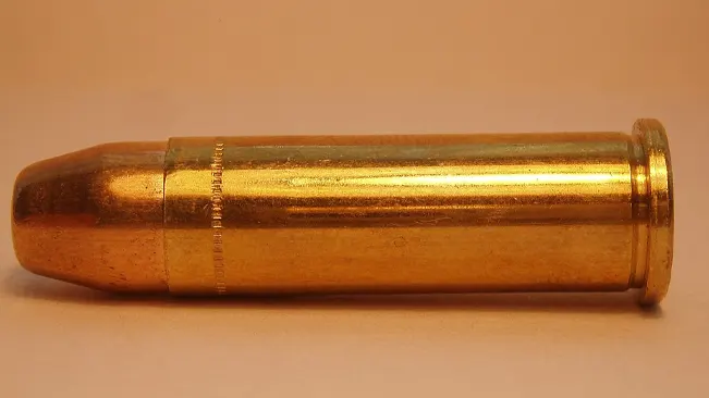 Golden bullet casing against an orange backdrop, possibly for an Astra 680.