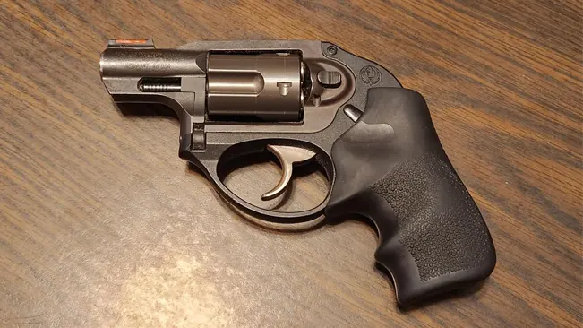 Ruger LCR revolver with exposed hammer and textured grips on a wood grain surface.