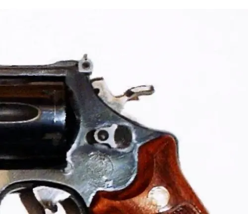 Close-up of the hammer and rear sight on a Smith & Wesson Model 29 revolver with wooden grips.