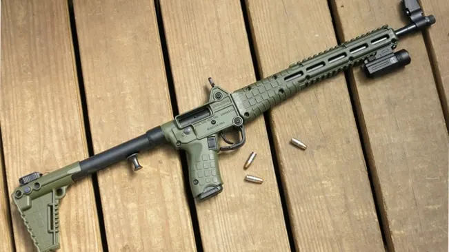 Kel-Tec SUB-2000 rifle on wooden surface with spent casings