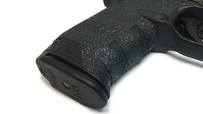 Close-up of the textured grip and magazine base of a Walther PPQ M2 handgun.