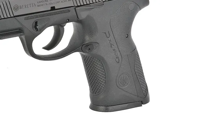 Profile view of a Beretta PX4 Storm subcompact pistol against a clear sky, with focus on the slide and safety features.