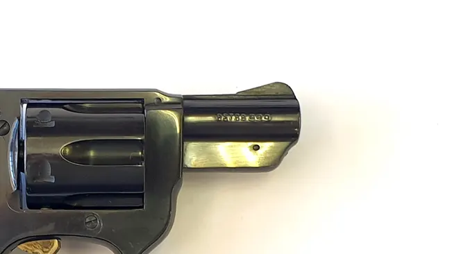 Close-up of the barrel of an Astra 680 revolver against a white background.