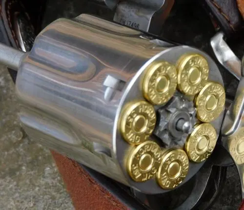Close-up of a loaded cylinder of a Smith & Wesson 686 Plus Deluxe revolver with brass cartridges.