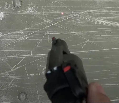 First-person view holding a Smith & Wesson M&P Bodyguard 38 with laser sight against a scratched metal surface.