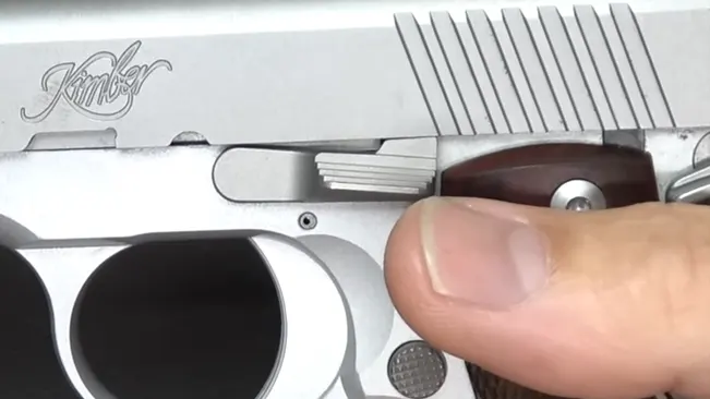 Close-up of the safety lever on a Kimber Micro 9 pistol with the Kimber logo on the slide.