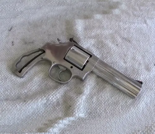 Smith & Wesson 686 Plus Deluxe revolver lying on a white textured surface.