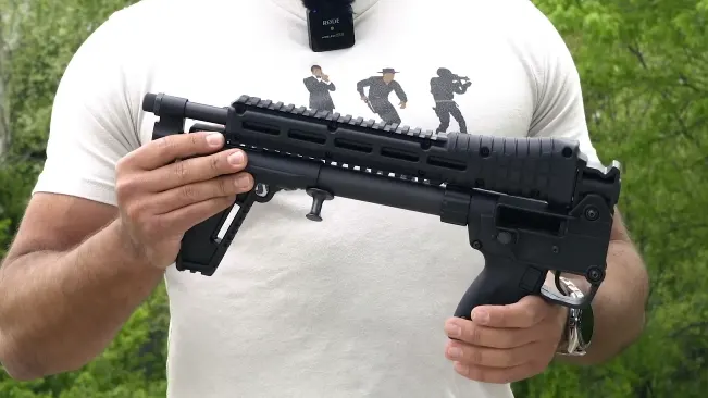 Person holding a folded Kel-Tec SUB-2000 rifle
