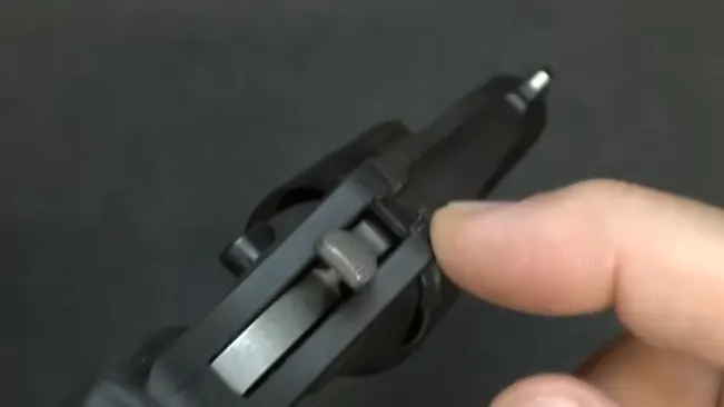 Person's finger pulling the trigger of a Ruger LCR revolver, focused on the hammer and firing mechanism.