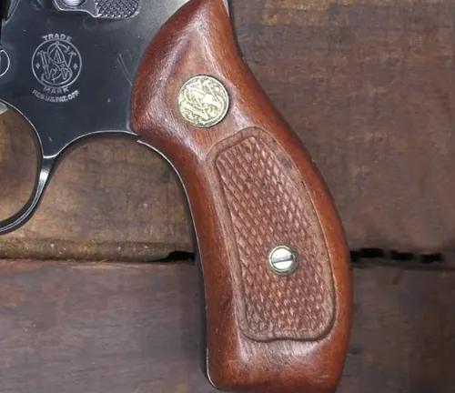 Detailed view of the wooden grip and emblem on a S&W Model 49 Bodyguard revolver.