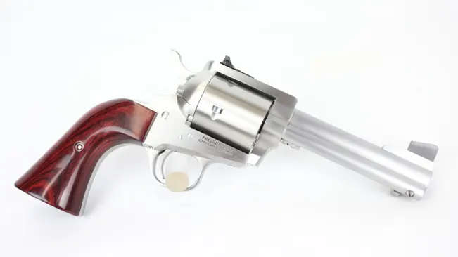 A Freedom Arms Model 83 revolver with a long barrel, stainless steel finish, and polished wooden grip on a white background.