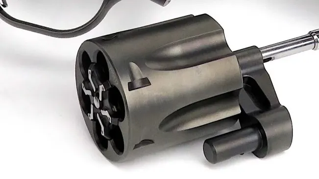 Close-up of the open cylinder and extraction rod of a Korth Nighthawk Mongoose revolver on a white background.