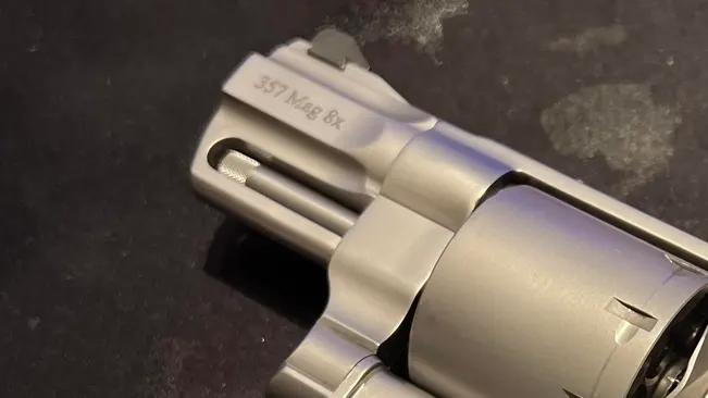 Close-up of the barrel of a Smith & Wesson 627 revolver with ".357 Mag 8x" engraving.