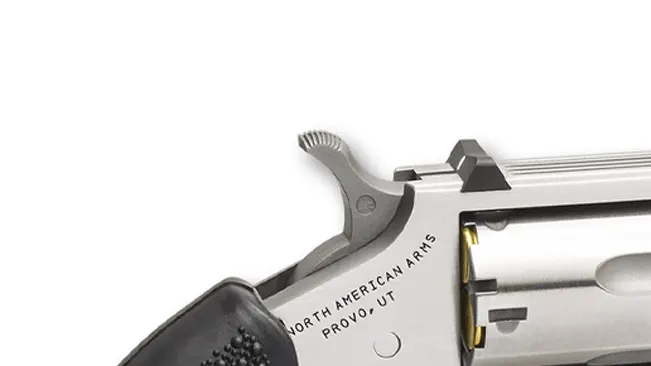 Close-up of the hammer and safety notch on a North American Arms Pug .22 revolver with engraved text.