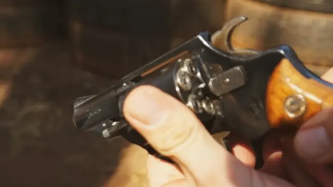 Close-up of a hand holding an Astra 680 revolver with the hammer pulled back.