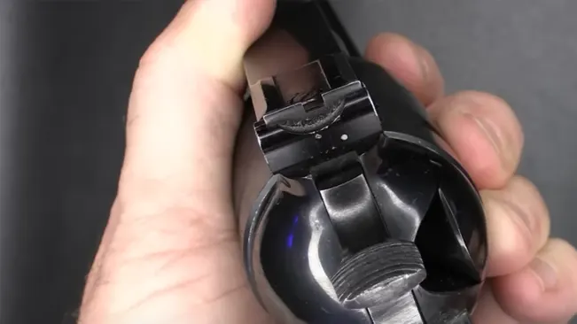 Hand holding a Ruger Super Blackhawk .44 revolver, focusing on the rear sight and hammer.