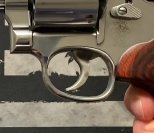 Hand on the trigger of a Smith & Wesson 686 Plus Deluxe revolver showing the trigger and guard.