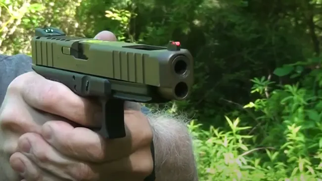 a man aiming to shoot using a Glock pistol