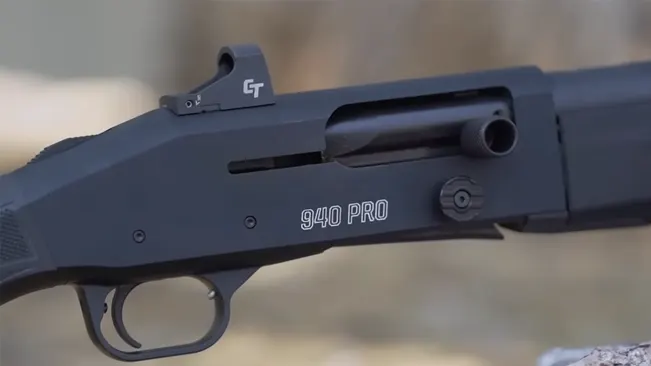 Close-up of a Mossberg 940 Pro Tactical shotgun's receiver with "940 PRO" marking and mounted optical sight.