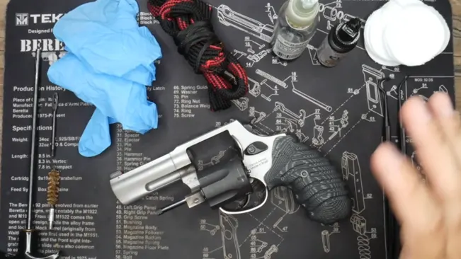 Taurus Defender 856 revolver on a cleaning mat with gun maintenance tools and supplies.