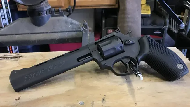 A Taurus Tracker 17 revolver placed on a wooden workbench.
