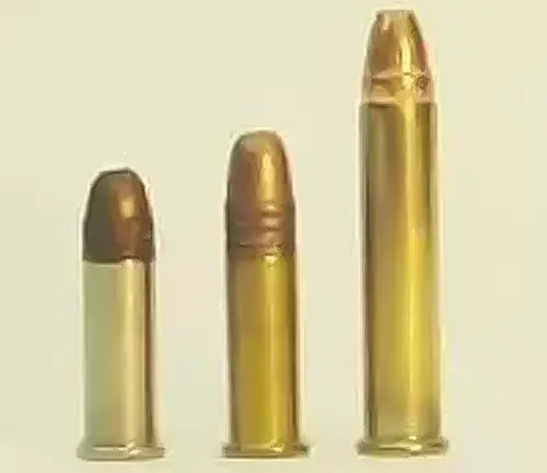 Three different calibers of handgun ammunition displayed in ascending size order on a light background.