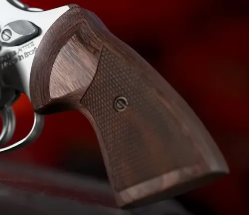 Wooden grip detail of a Taurus 856 Executive Grade revolver on a red background.