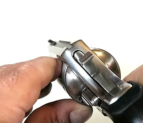 Hand adjusting the sight of a Rock Island Armory AL3.1 revolver.