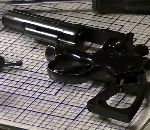 Disassembled Colt Trooper MK III revolver on a checked work mat.