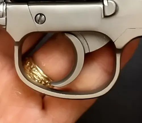 Close-up of the trigger and guard of a Rock Island M206 Spurless Matte revolver with a golden ring.