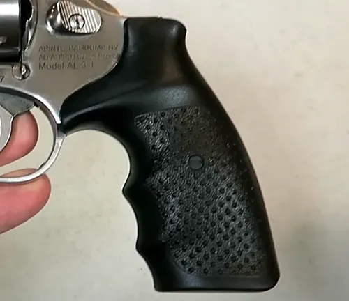 Hand holding a Rock Island Armory AL3.1 revolver, focusing on the textured grip.