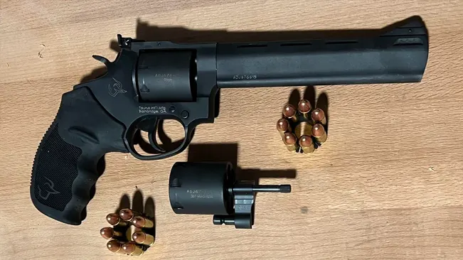 Taurus Tracker 17 revolver with additional cylinder and .17 HMR ammunition on a wooden surface.