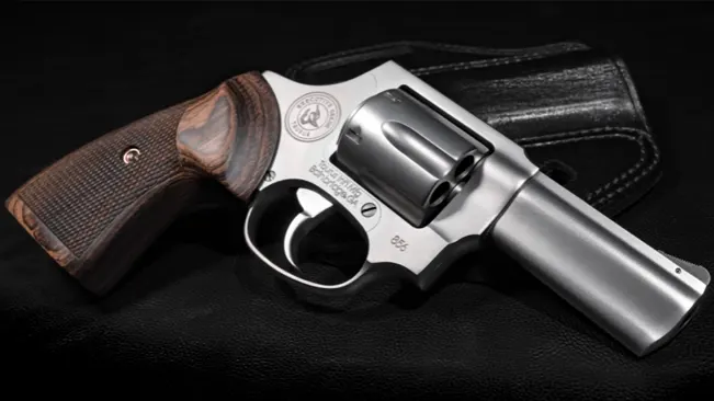 Taurus 856 Executive Grade revolver with wooden grips on a black leather background.